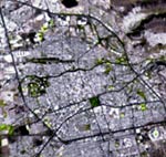 QUERETARO EN LA FOTO SATELITE. Se trato digitalmente para lograr la mayor visibilidad en la traza de calles y en las areas verdes.  
Al centro arriba (al norte) se aprecia el bordo Benito Juarez, en el parque Queretaro 2000; cerca de la esquina inferior izquierda, la plaza de toros Santa Maria y en la inferior derecha, el estadio Corregidora. La sensibilidad del satelite es tal que distinguimos algunas zonas arboladas (verde obscuro) en Av. Universidad y otras avenidas principales. 
En el centro se observan los rasgos mas prominentes que rodean al Centro Historico: A la izquierda, el arbolado del Cerro de Las Campanas. Bordeandolo por el norte, el rio Queretaro, que serpentea desde el este; y un poco hacia abajo, el cuadrangulo verde obscuro de la Alameda Hidalgo